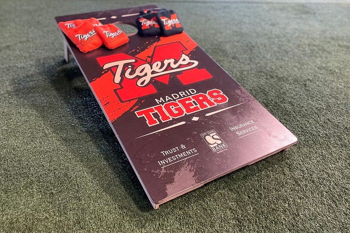 Custom Madrid Tigers cornhole board with matching red and black bags.